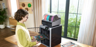 Woman using a 3D printer on a table at home.