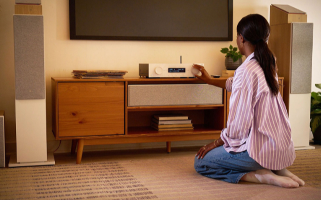 A person turns up the dial on the JBL MA Series AV Receiver.