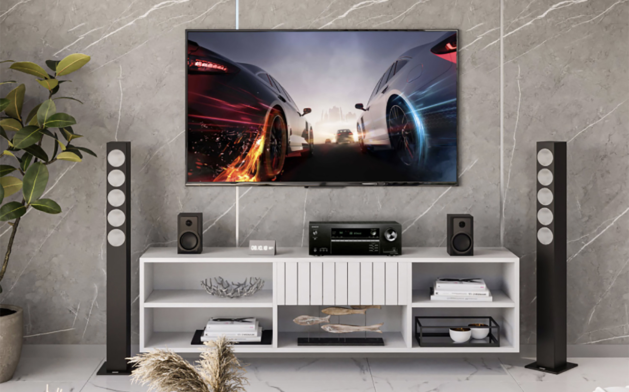 An Onkyo SR494 AV receiver in a room under a TV on white furniture. 