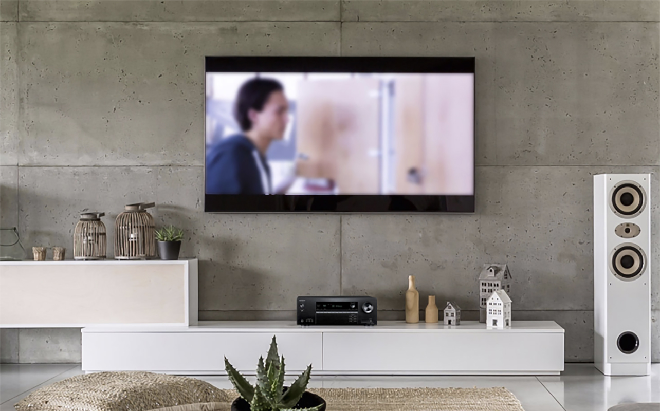 An Onkyo TSRX494 AV receiver in a living room set-up with white speakers.