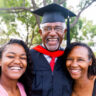 A senior man graduates with his master's degree and takes a photo with his family