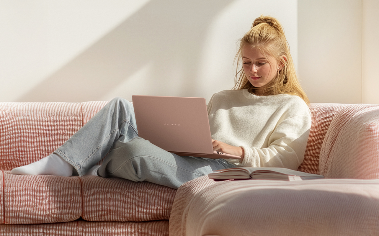 Young girl using a laptop on a couch.