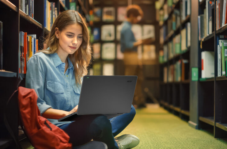 Young student in library using a laptop.