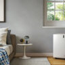 How much does an air conditioner cost in Canada? An air conditioner by a window in a bedroom.