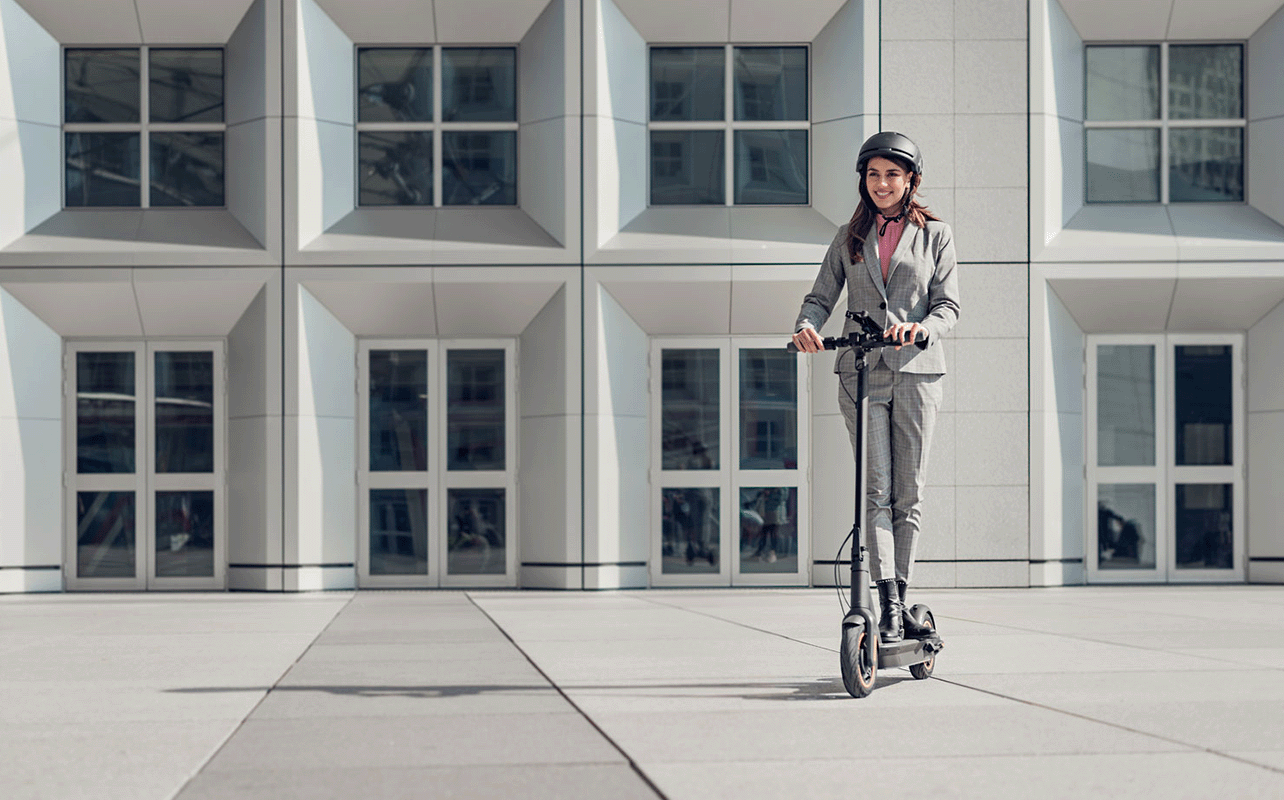 A person rides an e-scooter on the way to work.