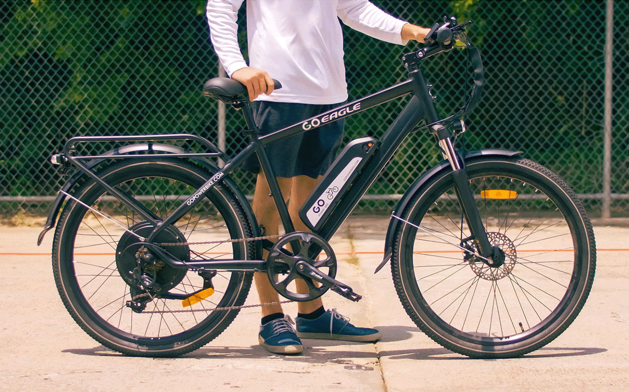 A person stands behind their e-bike. 