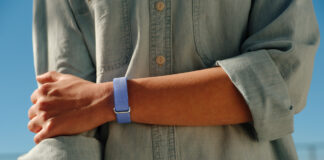 A person's arm across their body while wearing the Fitbit Air.