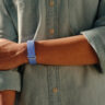 A person's arm across their body while wearing the Fitbit Air.