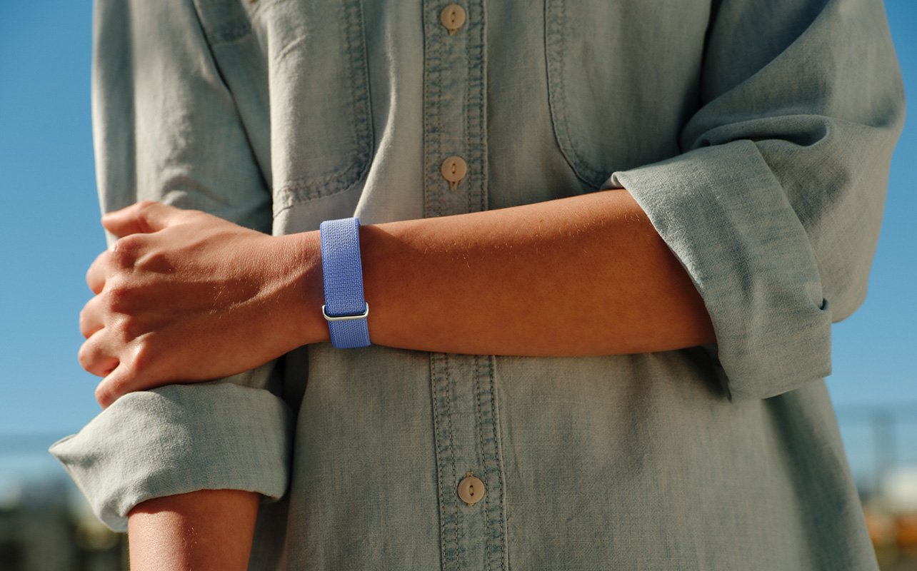 A person's arm across their body while wearing the Fitbit Air.