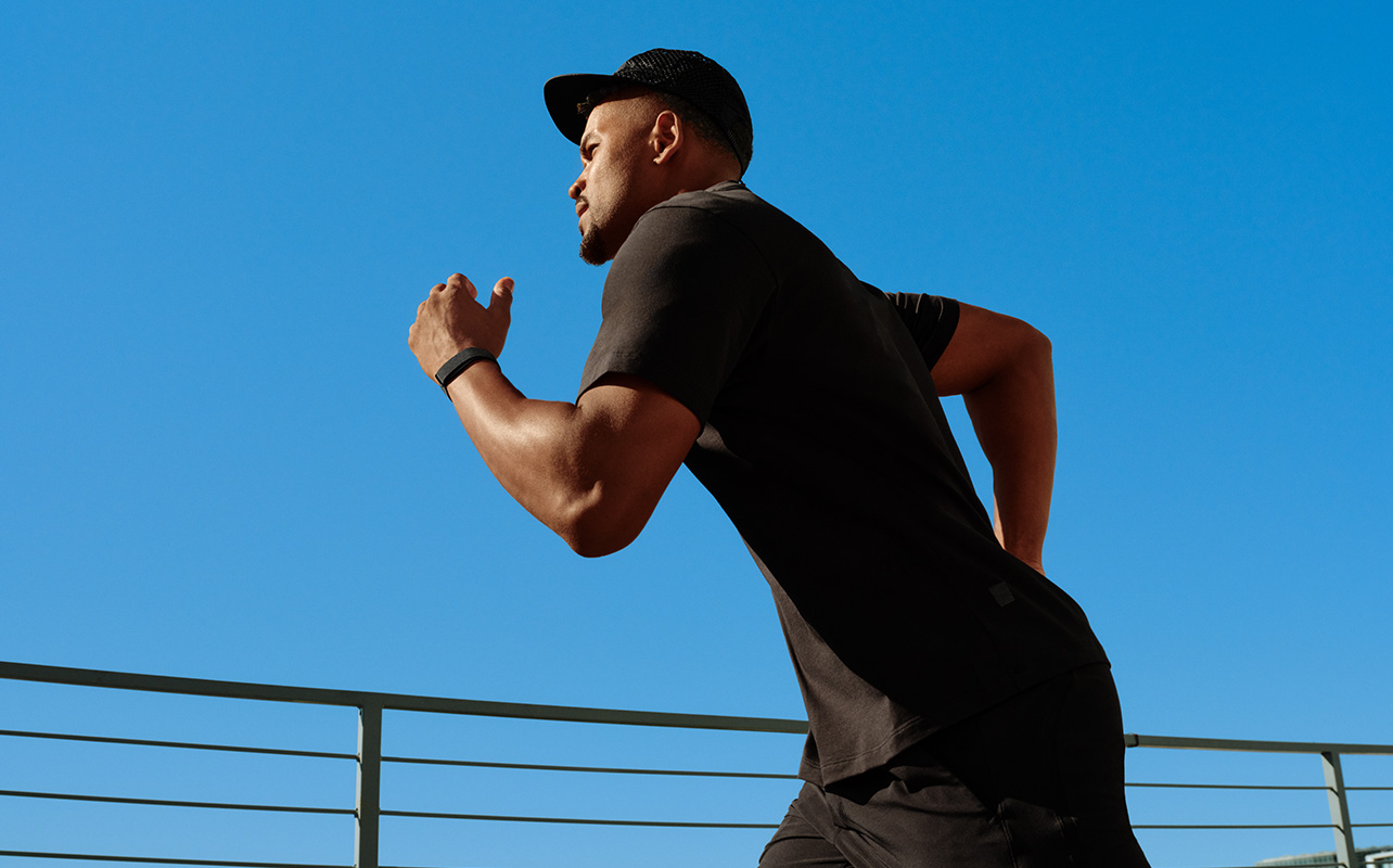 A man running while wearing the Fitbit Air.