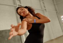 A woman dancing while wearing the Fitbit Air.
