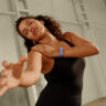 A woman dancing while wearing the Fitbit Air.