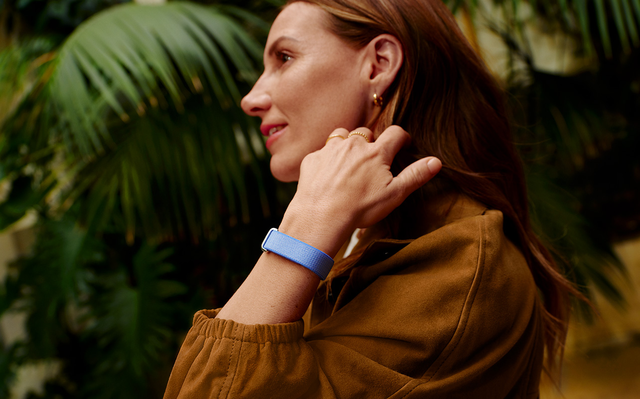 A woman smiling wearing the Fitbit Air.