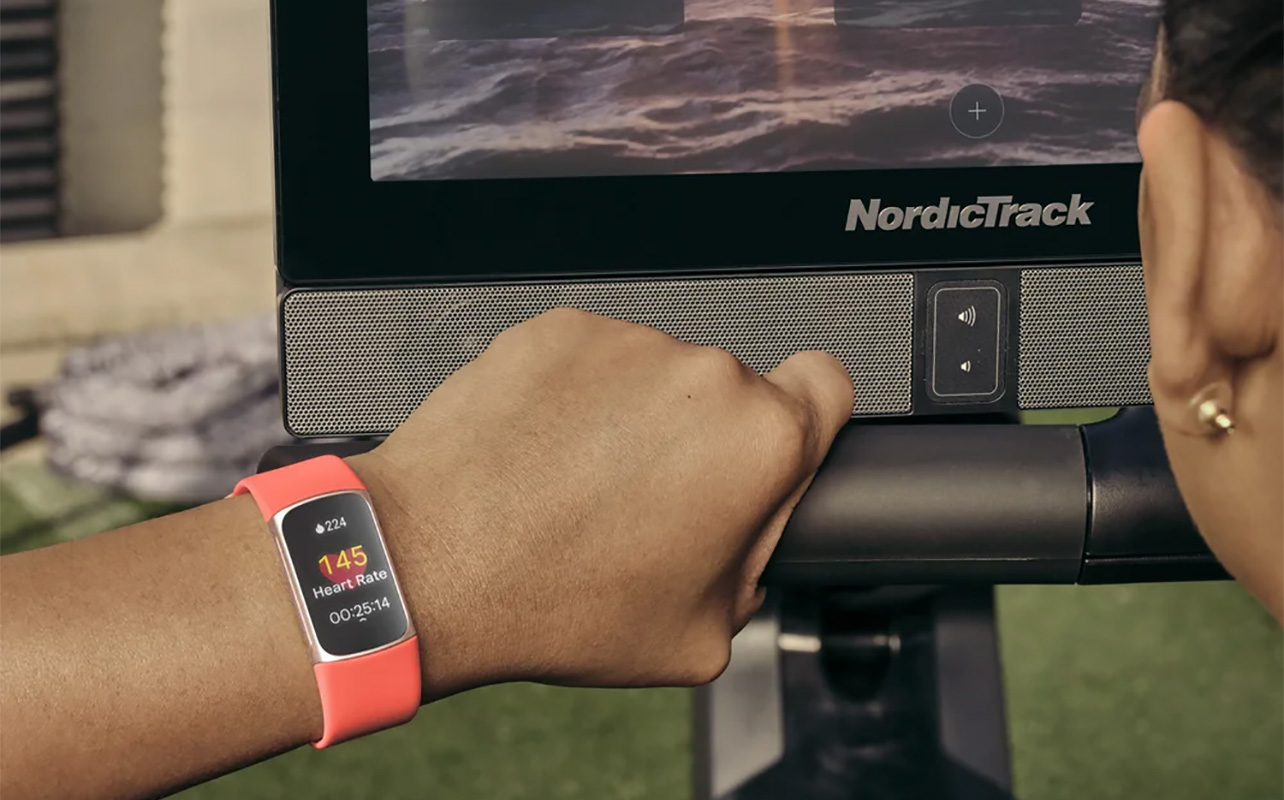 A woman on a gym machine wearing the Fitbit Charge 6.