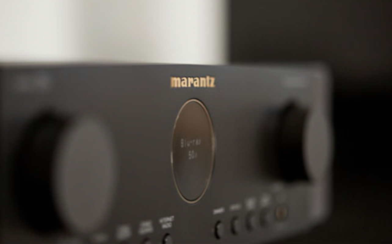 A close-up shot of the Marantz Cinema 70S receiver shows its brand  nameplate. 
