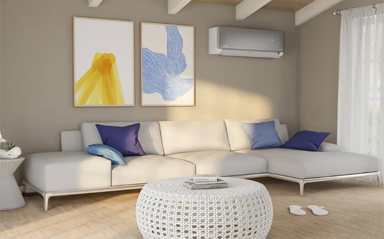 A mini split AC unit mounted on a wall in a living room.