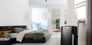A black portable air conditioner in a bedroom.