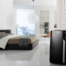 A black portable air conditioner in a bedroom.