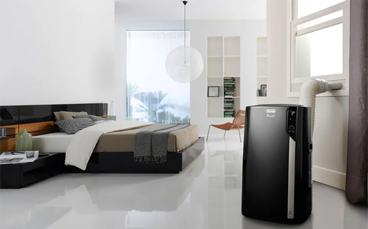 A black portable air conditioner in a bedroom.
