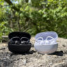 Shokz OpenDots 2 and OpenDots Air in their cases outside on a rock.