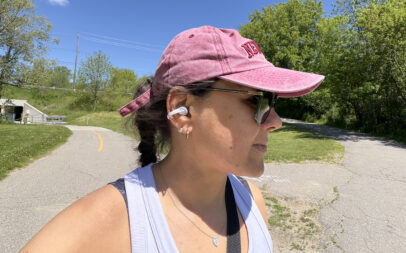 A woman wearing the Shokz OpenDots Air earbuds outside.