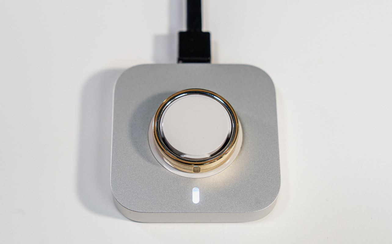 Oura Ring 5 charging in cradle.