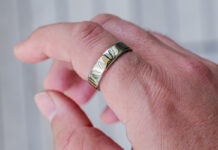 Oura Ring 5 in gold on index finger.
