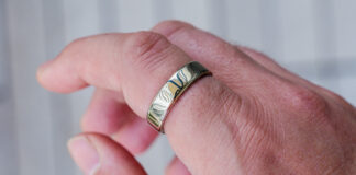 Oura Ring 5 in gold on index finger.
