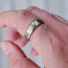 Oura Ring 5 in gold on index finger.