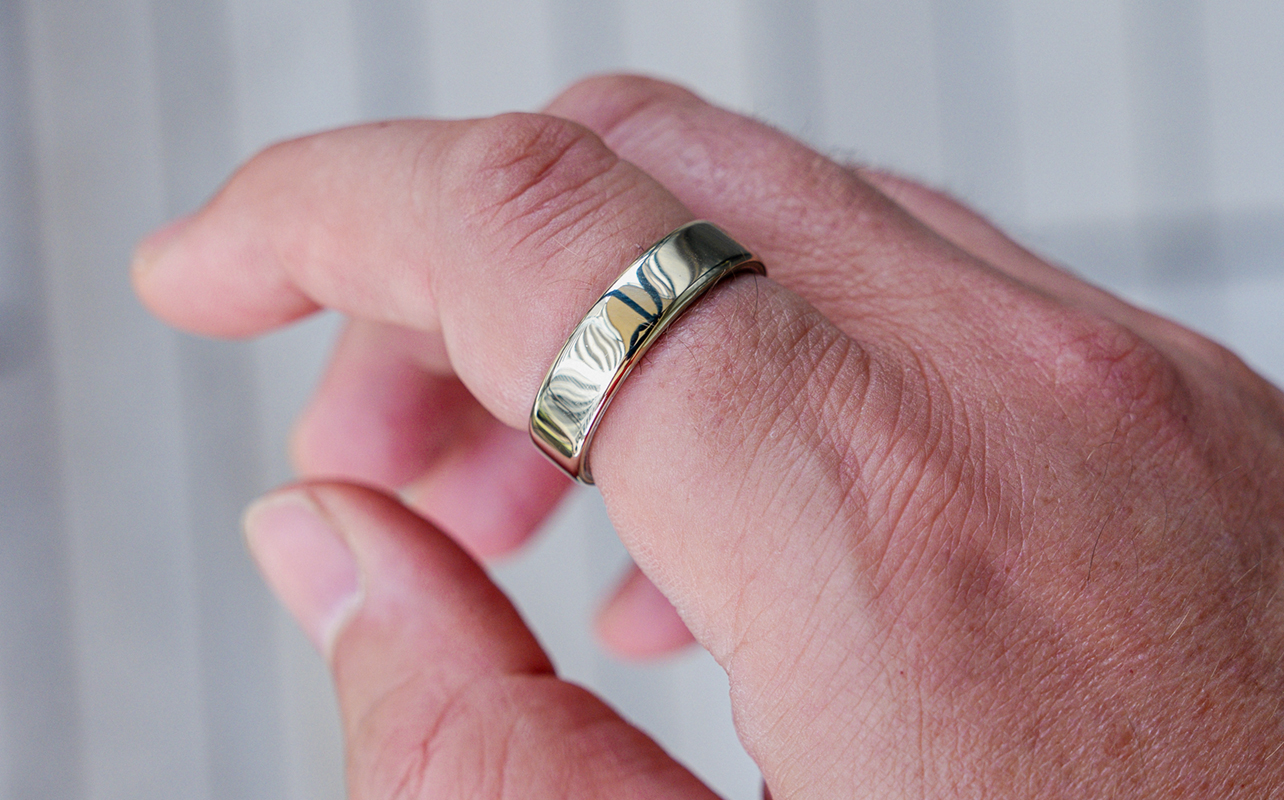 Oura Ring 5 in gold on index finger.