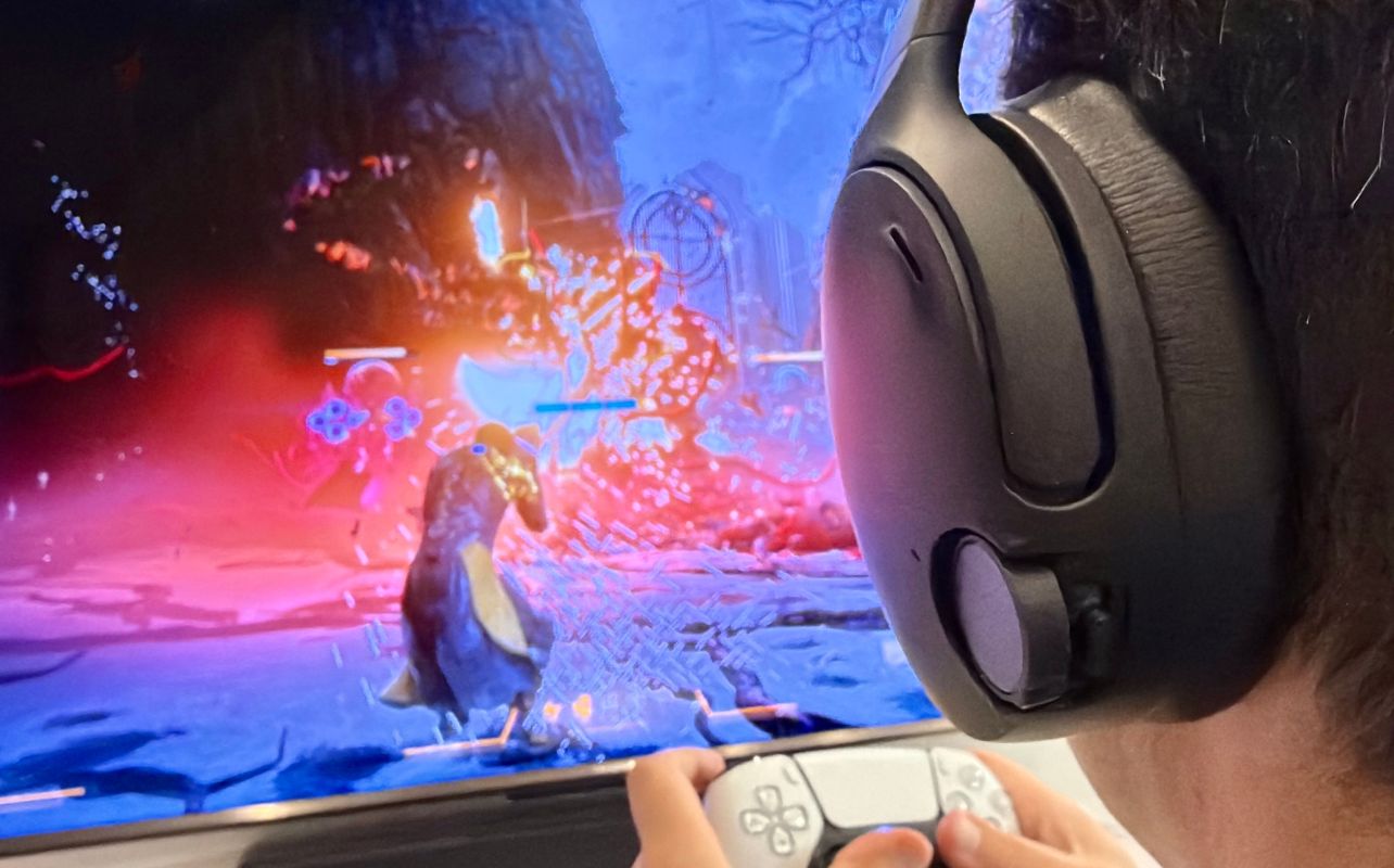 A person plays Saros while enjoying the audio from the Skullcandy Crusher 1080 ANC headset.