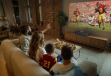 The best ultra short throw projectors to replace your TV A family watching TV in the living room with the Epson Lifestudio Grand Plus projector.