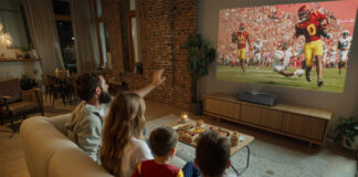 A family watching TV in the living room with the Epson Lifestudio Grand Plus projector.