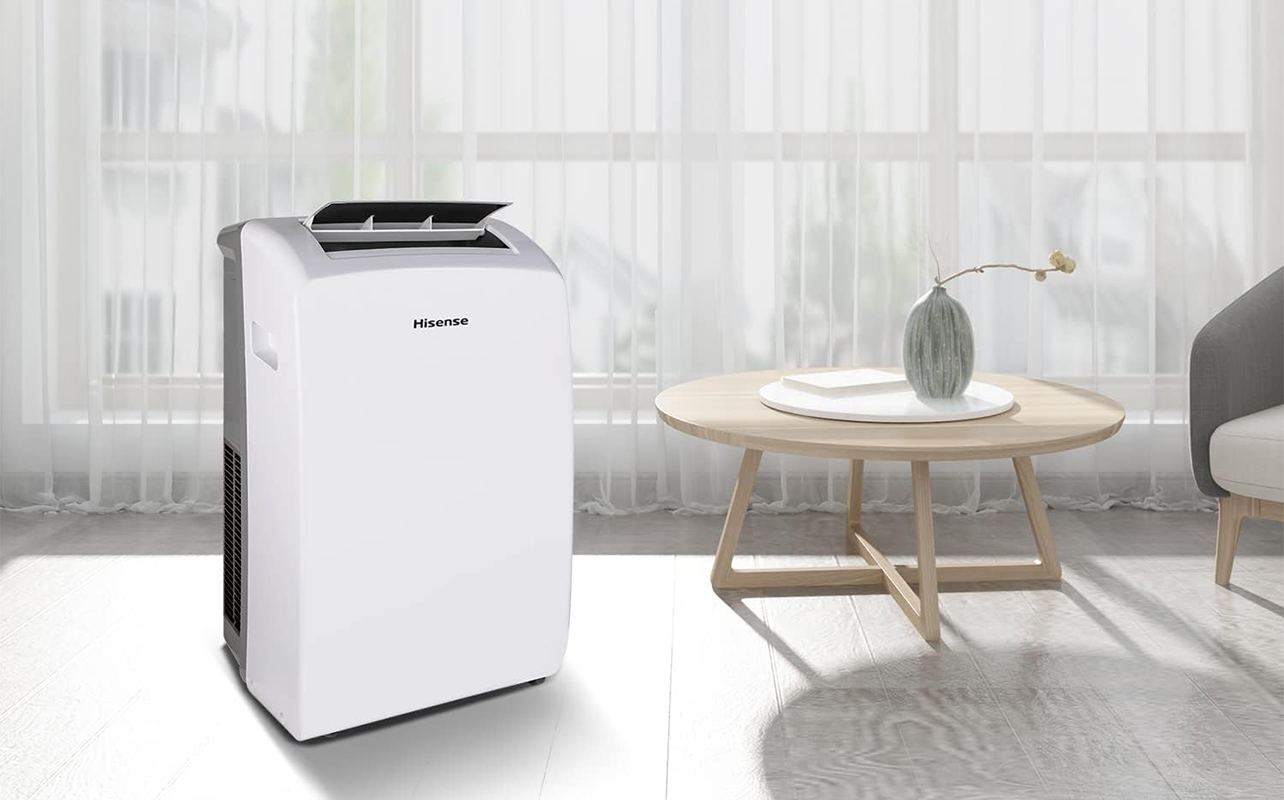 A Hisense portable air conditioner by a large window in a living room.