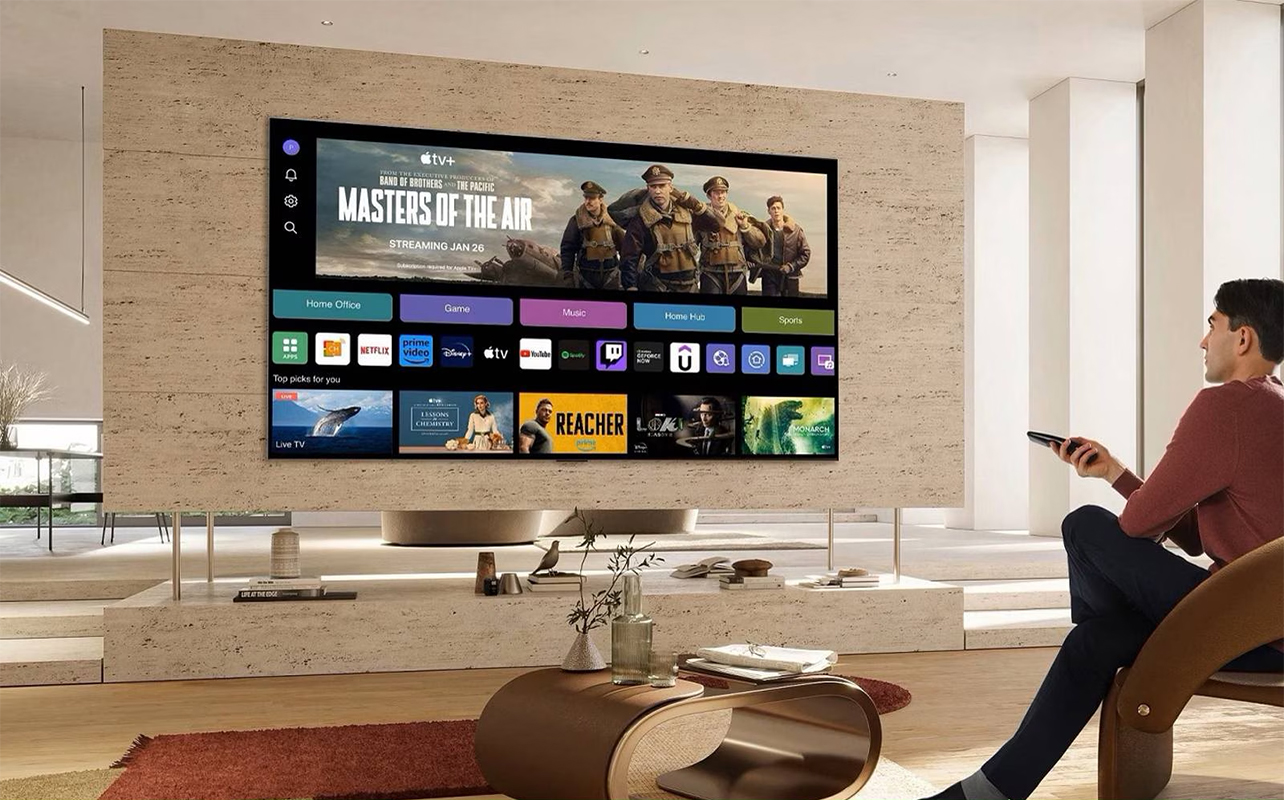 A person sitting in frot of an LG AI TV showing a streaming service menu screen.
