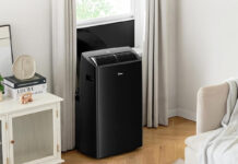 A black Midea portable air conditioner mounted at a window.