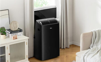 A black Midea portable air conditioner mounted at a window.
