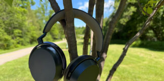 The Sennheiser Momentum 5 Wireless headphones hanging on tree branches.