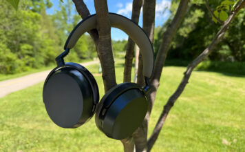 The Sennheiser Momentum 5 Wireless headphones hanging on tree branches.