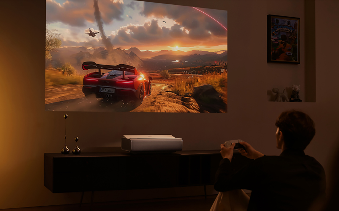 A person gaming at night with the XGIMI Aura 2 ultra short throw projector.