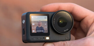 Man holding DJI Osmo Action 6 at himself outdoors.