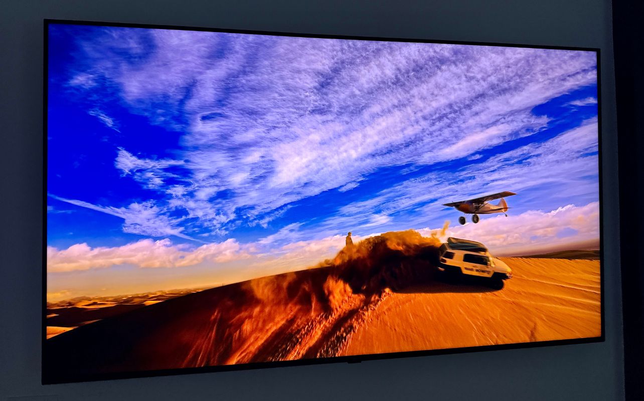 A car jumps into the sky with a plane on the LG Micro RGB evo TV display.