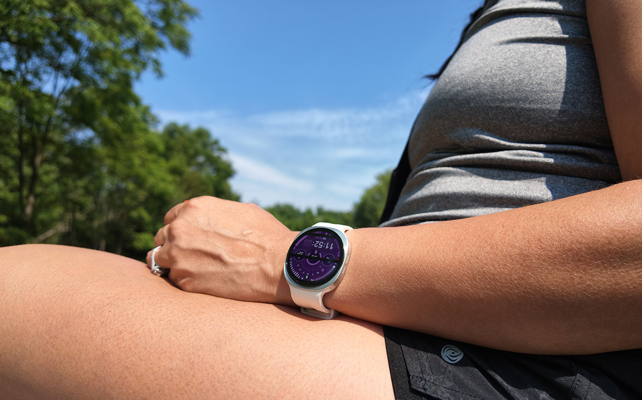 Samsung Galaxy Watch 9 on a wrist resting on a leg outside.