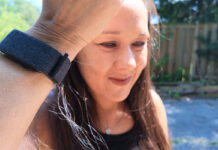 A woman holding up her arm with th Garmin CIRQA smart band.