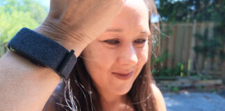 A woman holding up her arm with th Garmin CIRQA smart band.