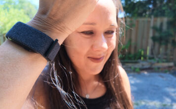 A woman holding up her arm with th Garmin CIRQA smart band.