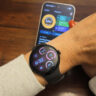 The Google Pixel Watch 5 on an arm with the Google Pixel 11 Pro in the background showing the Google Health app