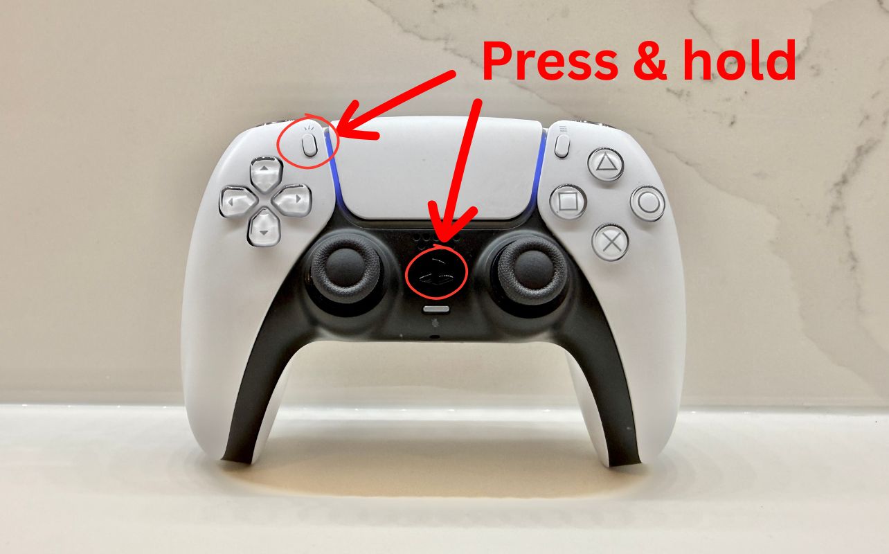 A PS5 DualSense controller with red arrows and lines that display, "Press & hold"