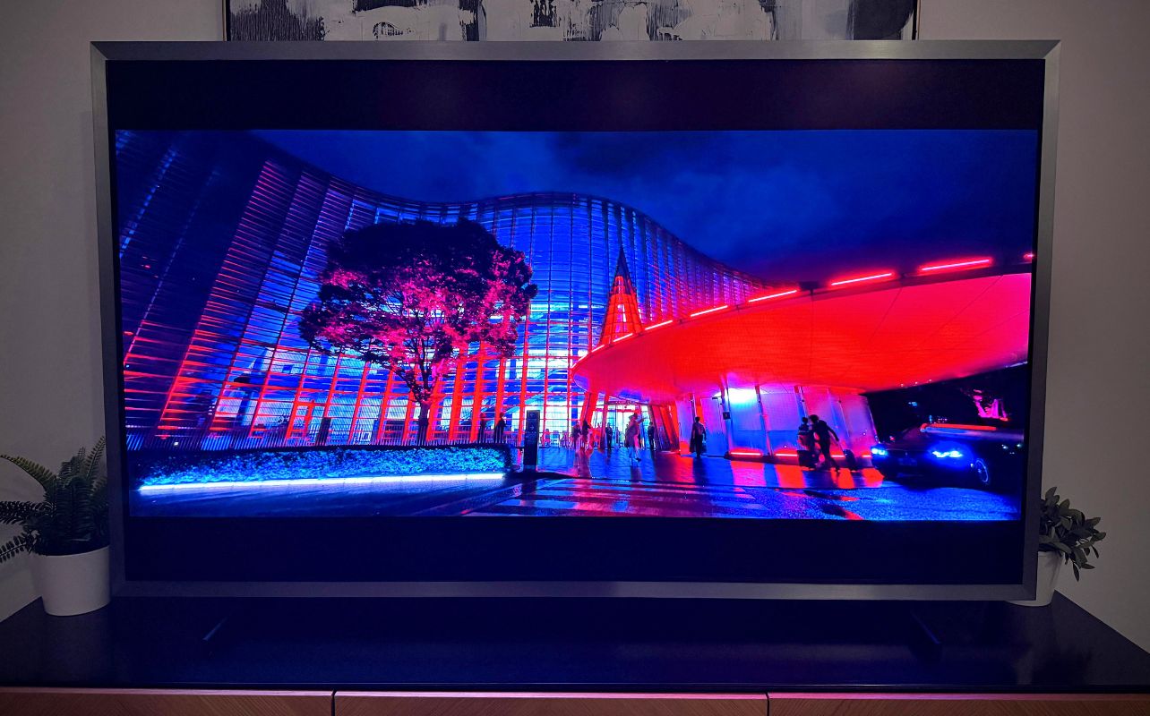 Samsung S95H image with a building on screen illuminated by red lights.