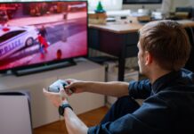 Gamer playing on PS5 with a DualSense wireless controller in front of a TV.